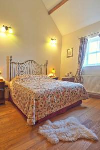 a bedroom with a bed and a rug on the floor at Kidwelly Farmhouse in Kidwelly