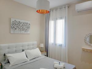 - une chambre blanche avec un lit et une fenêtre dans l'établissement Nikola's & Joanna's apartments 2, à Argostóli