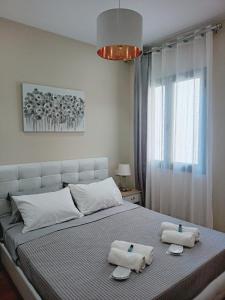 - une chambre avec un grand lit et des serviettes dans l'établissement Nikola's & Joanna's apartments 2, à Argostóli