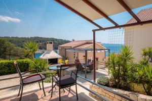 a patio with chairs and a table on a balcony at Apartments Babic in Milna