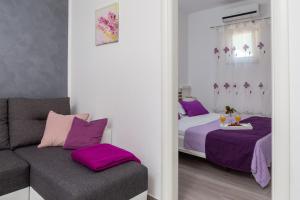 a room with two beds and a couch and a mirror at Apartments Babic in Milna
