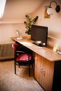una scrivania con computer e sedia in una stanza di Penzion Tilia a Levice
