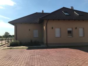 a house with a brick driveway in front of it at Bencsik Vendégház in Szentkirály