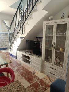 a living room with a tv and a staircase at Casa Rosarito in Aracena