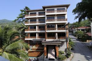 ein hohes Gebäude mit Balkon auf einer Straße in der Unterkunft Sun Hill Hotel Patong in Patong Beach