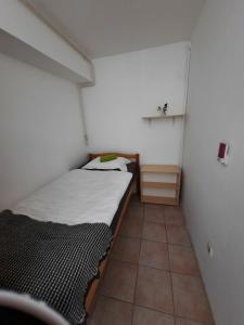 a small bedroom with a bed and a tiled floor at Apartment Klementina FREE PARKING in Zagreb