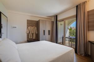 Un dormitorio con una gran cama blanca y una mesa en Your lovely and elegant home with garden sea view en La Maddalena