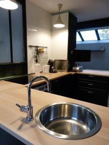 a kitchen counter with a stainless steel sink at 51 côté jardin in Selvigny