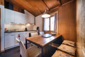 uma cozinha com uma mesa de madeira e uma sala de jantar em Chalet Höckli Wohnung 1. em Arosa