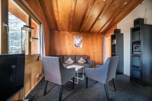 a living room with a couch and a table and chairs at Chalet Höckli Wohnung 1. in Arosa