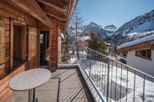 uma varanda com uma mesa e vista para as montanhas em Chalet Höckli Wohnung 1. em Arosa