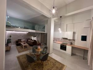 een keuken en een woonkamer met een tafel en een bank bij Votsalo Corfu town apartment in Ágios Rókkos