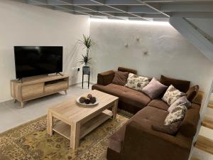 Il comprend un salon doté d'un canapé et d'une télévision à écran plat. dans l'établissement Votsalo Corfu town apartment, à Ágios Rókkos