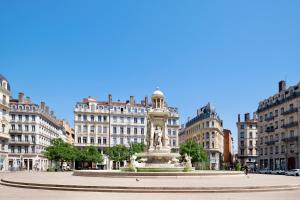 una fuente en medio de una ciudad con edificios en HONORÊ SUITE DU TEMPLE, en Lyon