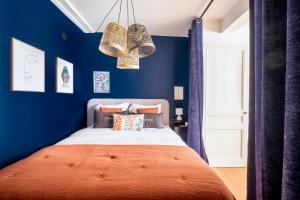 1 dormitorio azul con 1 cama grande y paredes azules en HONORÊ SUITE DU TEMPLE en Lyon