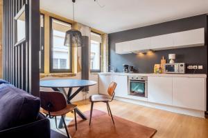 cocina y sala de estar con mesa y sillas en HONORÊ SUITE DU TEMPLE en Lyon