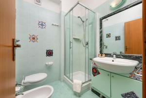 a bathroom with a sink and a toilet and a shower at I Tre Golfi Beach Apartments in San Vito lo Capo +54 photos