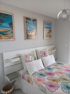 a bedroom with a bed with a colorful comforter at Les Goélands de l'Océan in Vieux-Boucau-les-Bains