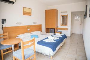 1 dormitorio con 1 cama, mesa y sillas en Cornelia Hotel en Ayia Napa