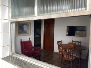 ein Esszimmer mit Tisch und Stühlen und einem Spiegel in der Unterkunft Pe na Areia Canto do Forte, Wi-Fi,Estacionamento in Praia Grande