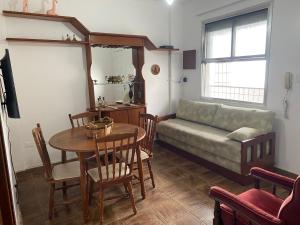 ein Wohnzimmer mit Tisch und Couch in der Unterkunft Pe na Areia Canto do Forte, Wi-Fi,Estacionamento in Praia Grande