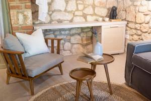 a living room with a chair and a table with a book at Petrino Eco Village in Afitos