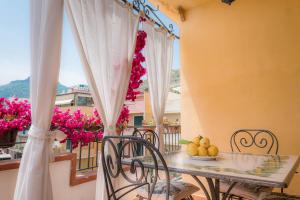 een balkon met een tafel, stoelen en bloemen bij Case Borgo Vacanze in Letojanni