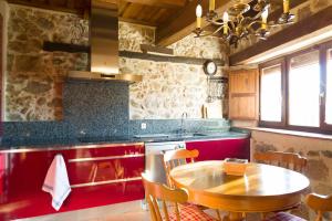 a kitchen with a wooden table and a counter top at El Zaguán de Cabanillas in Cabanillas del Monte +13 photos