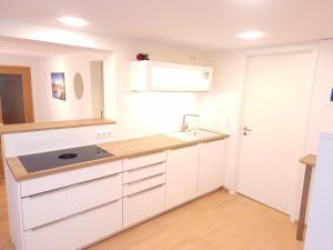 a kitchen with white cabinets and a sink at Liebevoll renoviertes Haus mit großem Garten in Dresden in Dresden