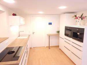 a kitchen with white cabinets and a counter top at Liebevoll renoviertes Haus mit großem Garten in Dresden in Dresden