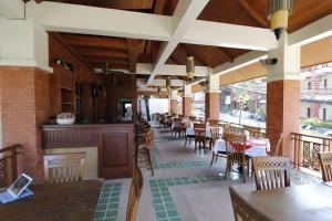 ein Restaurant mit Tischen und Stühlen und einer Bar in der Unterkunft Sun Hill Hotel Patong in Patong Beach