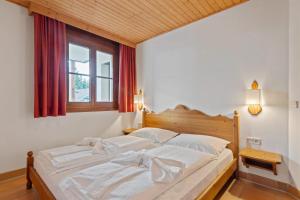 a bedroom with a bed with white sheets and a window at Apartment 2205 Kanzelhöhe in Treffen