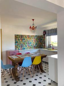 a kitchen with a wooden table and colorful chairs at Mechechill in Mechelinki