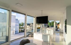 a living room with a tv and some glass windows at Izi Apartman in Fonyód