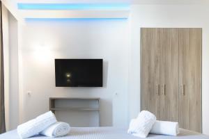 a bedroom with a bed with a tv on the wall at Summer In in Polychrono