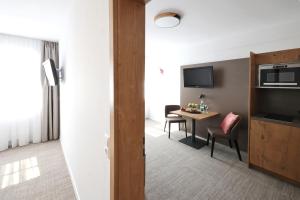 a hotel room with a table and a room at Hotel Gasthof Jägerstüble in Freudenstadt