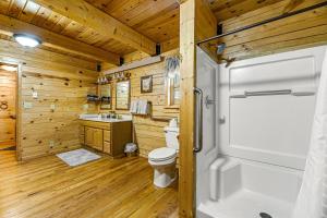 a log cabin bathroom with a toilet and a shower at Waterwheel Retreat in Sturgis +16 photos