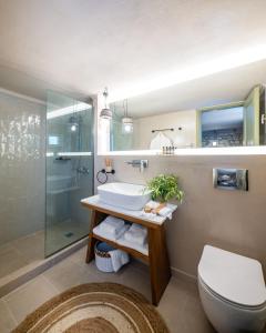 a bathroom with a toilet and a sink and a shower at Petrino Eco Village in Afitos