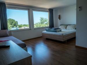 a room with a bed and a couch and windows at Vila Alga in Sulina