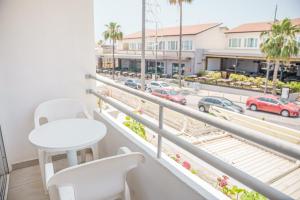 einen Balkon mit einem Tisch und Stühlen sowie Blick auf einen Parkplatz in der Unterkunft Cornelia Hotel in Ayia Napa