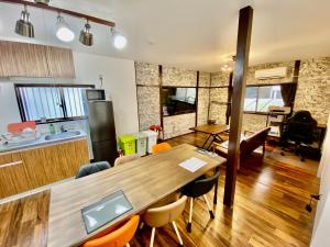 cocina y comedor con mesa de madera y sillas en ARS HOTEL Utsunomiya フロア貸切, en Utsunomiya