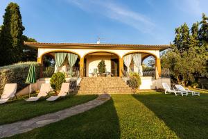 a house with a porch with chairs and a lawn at Agriturismo San Filippo in Campagnatico