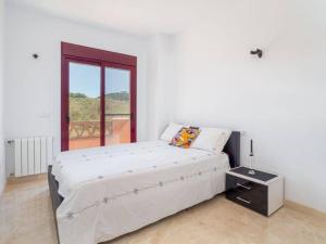 a white bedroom with a large bed and a window at Villa HEIDI in Málaga
