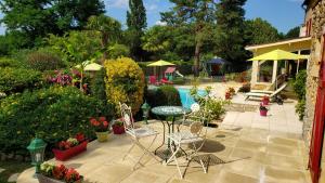 une terrasse avec une table, des chaises et une piscine dans l'établissement Domaine de la Dame Blanche, à Siorac-en-Périgord