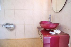 a bathroom with a bowl sink on top of a suitcase at Villa Spiros Imerolia Kassiopi in Kassiopi