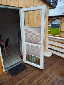 una puerta abierta de una casa con porche en Domek DaNutka w Sarbinowie, en Sarbinowo