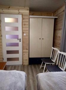 1 dormitorio con 2 sillas, armario y puerta en Domek DaNutka w Sarbinowie, en Sarbinowo