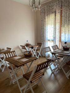 una sala da pranzo con tavoli, sedie e lampadario a braccio di Sogni e Colori a Villanova dʼAlbenga