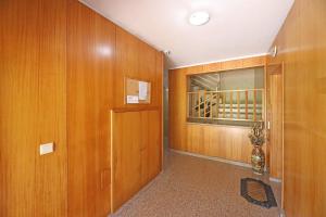 einen Flur mit Holzvertäfelung, einer Tür und einem Fenster in der Unterkunft FLH Gaia Valadares Comfy Apartment in Vila Nova de Gaia
