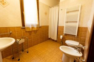 a bathroom with two toilets and a sink and a window at Agriturismo San Filippo in Campagnatico